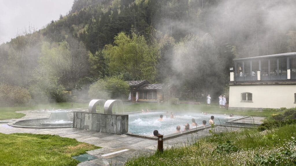 Vue latérale du grand bassin thermal extérieur fumant, ambiance brumeuse