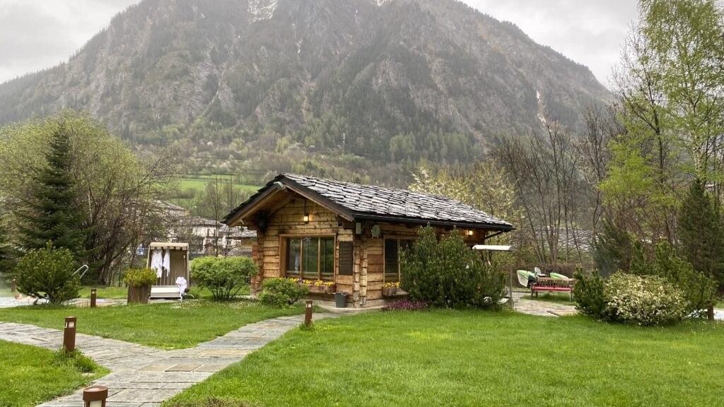 Chalet en bois abritant un sauna avec vue sur les montagnes verdoyantes