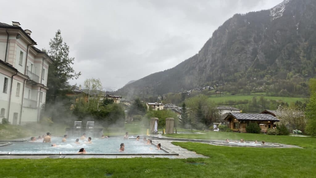 Grand bassin thermal extérieur avec vue sur les montagnes et les Alpes enneigées