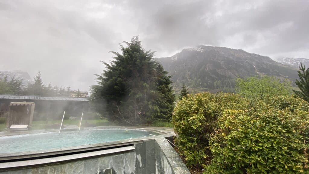 Petit bassin extérieur très chaud entouré de verdure et de vapeur