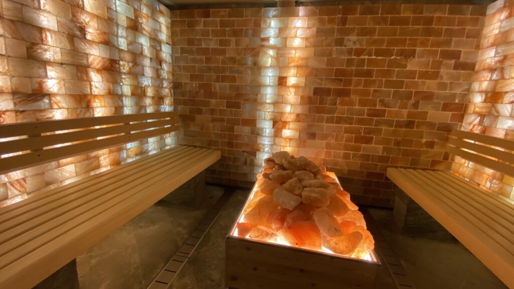 Grotte de sel aux murs de briques orangées et lampe en cristal de sel, ambiance cocon